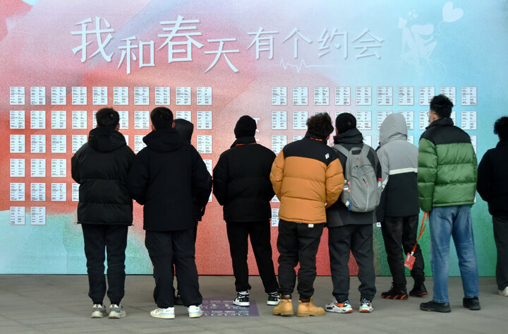 Đàn ông xem thông tin tìm kiếm người hẹn hò tại một sự kiện mai mối ở Hàng Châu, tỉnh Chiết Giang, Trung Quốc, ngày 25/2. (Ảnh: VCG)