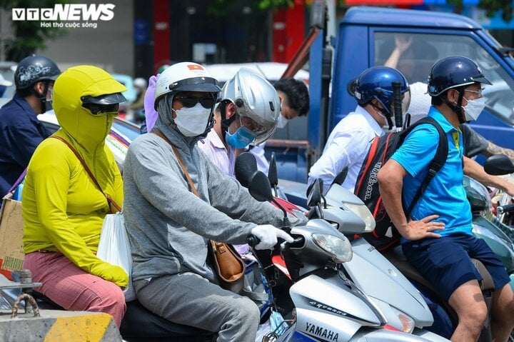 Nhiệt độ ngoài trời tăng cao, hầu hết người đi đường đều mặc đồ bảo hộ chống nắng nóng. (Ảnh: Đắc Huy)