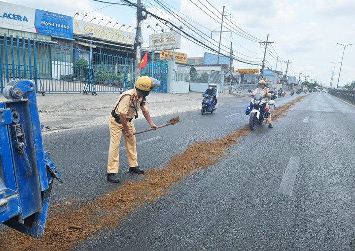 Cảnh sát Giao thông đã rải cát xuống đường để các xe máy không bị trượt ngã.