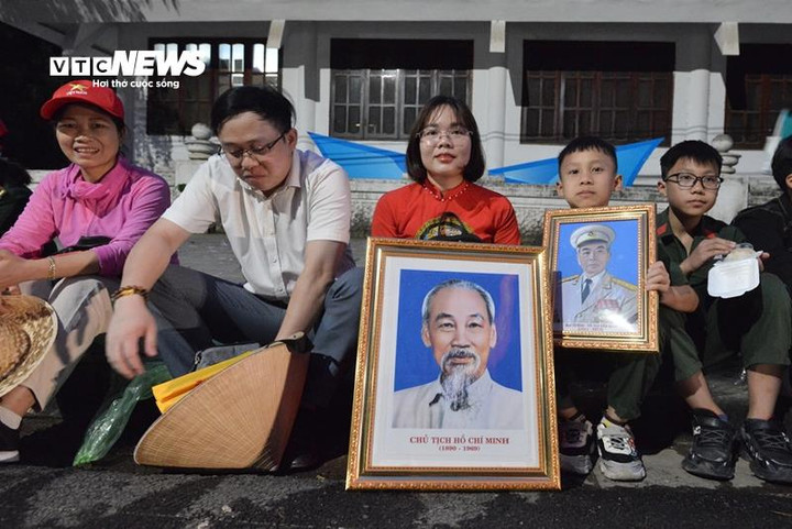 Chân dung Chủ tịch Hồ Chí Minh và Đại tướng Võ Nguyên Giáp được một gia đình trân trọng mang theo khi đi xem cuộc diễu binh lịch sử.