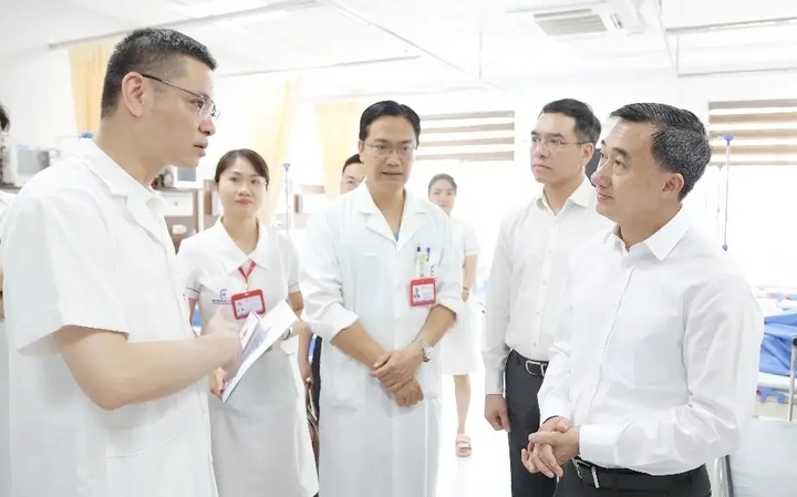 PGS.TS Đào Xuân Thành - Phó Giám đốc Bệnh viện Đại học Y Hà Nội báo cáo với GS Trần Văn Thuấn về sức khỏe của nữ bác sĩ nội trú Hoàng Minh Lý. (Ảnh: Trần Minh)