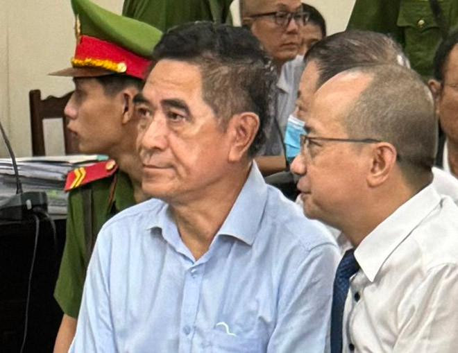 Cựu Chủ tịch UBND tỉnh Lào Cai Doãn Văn Hưởng (bên trái) tại tòa.