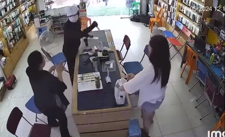 Hình ảnh tên cướp vung dao đe dọa cướp tài sản.