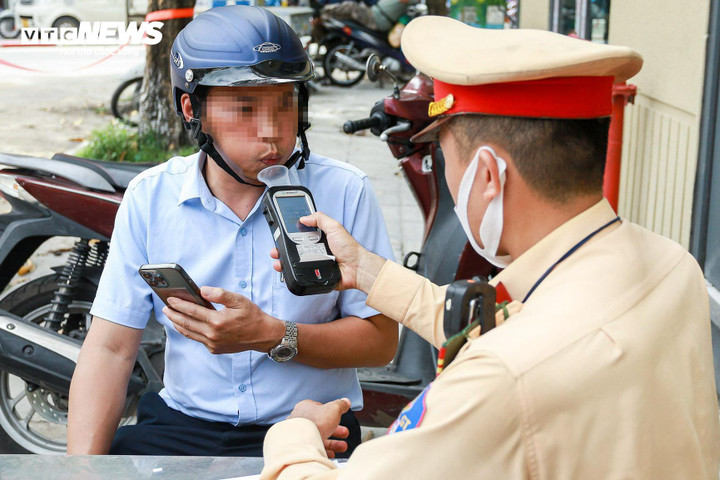CSGT kiểm tra nồng độ cồn với anh H. (Ảnh: Viên Minh)