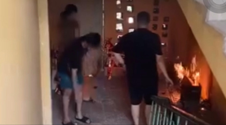 Dù được nhắc nhở nhưng những người này vẫn thản nhiên đốt vàng mã tại cầu thang khu tập thể. (Ảnh chụp màn hình)