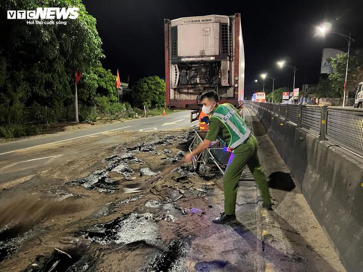 Cán bộ công an xã dọn dẹp dầu loang giữa đường. (Ảnh: CTV)