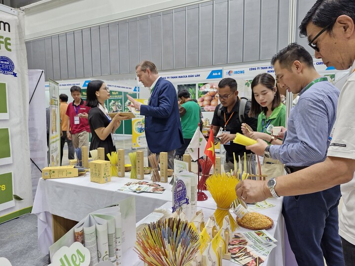 Khách quốc tế tìm hiểu sản phẩm ống hút được làm từ gạo, mì của doanh nghiệp Việt. (Ảnh: H. Linh)