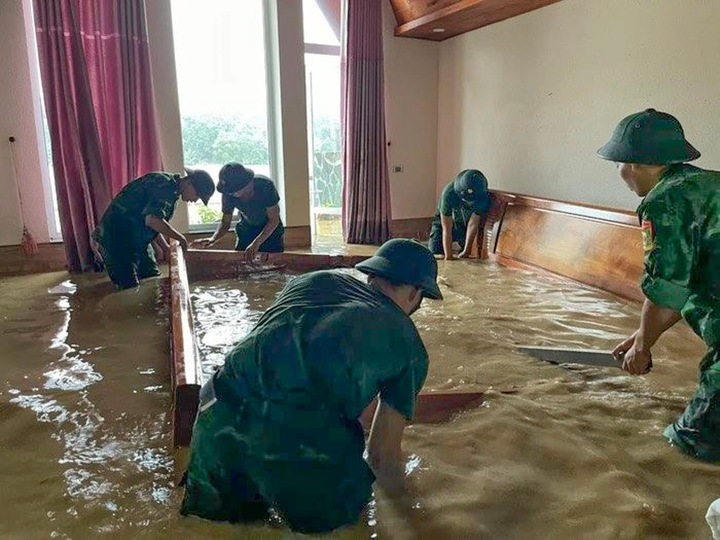 Bộ đội giúp dân tháo giường, tủ để di dời đến nơi an toàn.