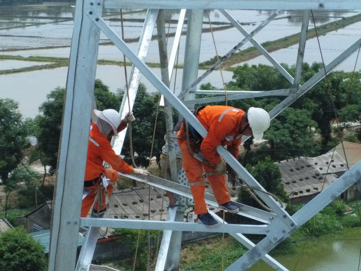 Lực lượng xung kích của PC Đồng Nai lắp ráp các thanh giằng trên cao.