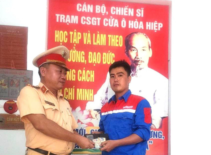 Cán bộ Trạm Cảnh sát Giao thông Hòa Hiệp trao trả tài sản cho anh Lê Quốc Việt.