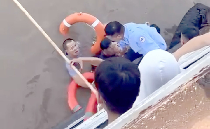Nhân viên bến phà và du khách ném phao cứu sinh, nhảy xuống sông cứu nam thanh niên đưa lên phà.