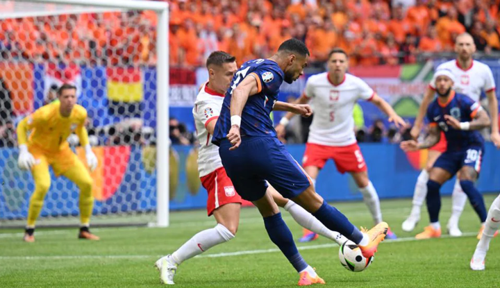 Hà Lan (áo xanh) uy hiếp khung thành Ba Lan.