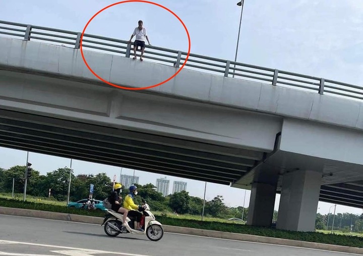 Người đàn ông trèo qua lan can cầu vượt rồi nhảy xuống đường.