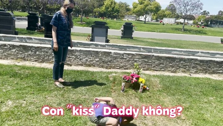 Con gái Đức Tiến cúi người hôn vào mộ bố.