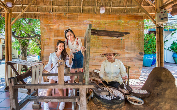 Du khách hóa thân thành nghệ nhân dệt lụa tơ tằm.