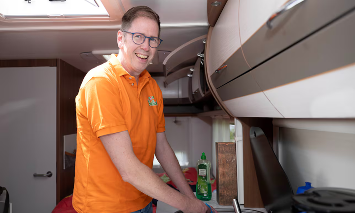 Cổ động viên Hà Lan rửa bát trong xe lưu động. (Nguồn: AS)