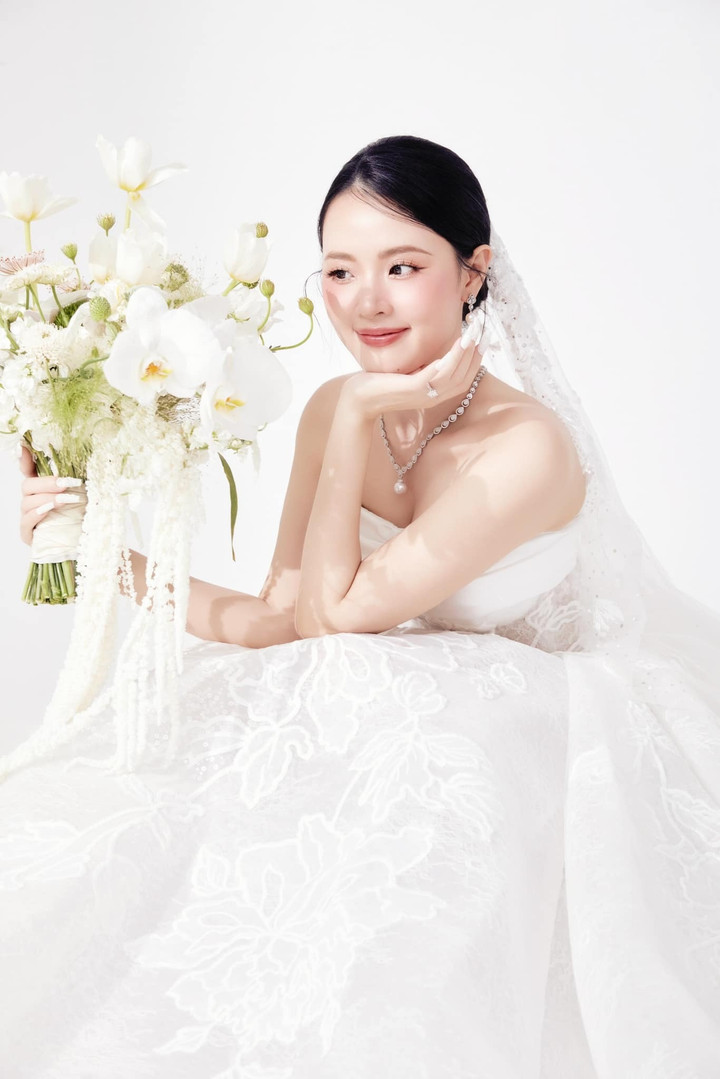 Những họa tiết hoa tinh tế trải dọc thân váy tạo nên sự lãng mạn và nữ tính, làm nổi bật vẻ đẹp tự nhiên của cô dâu Midu trong sự kiện trọng đại này.
