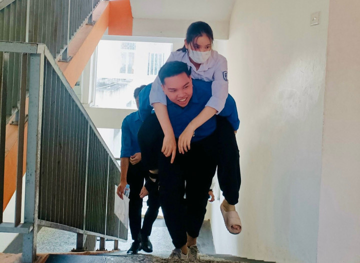 Dù phòng thi ở trên tầng cao nhưng các tình nguyện viên vẫn nở nụ cười rạng rỡ, tiếp lửa cho thí sinh.