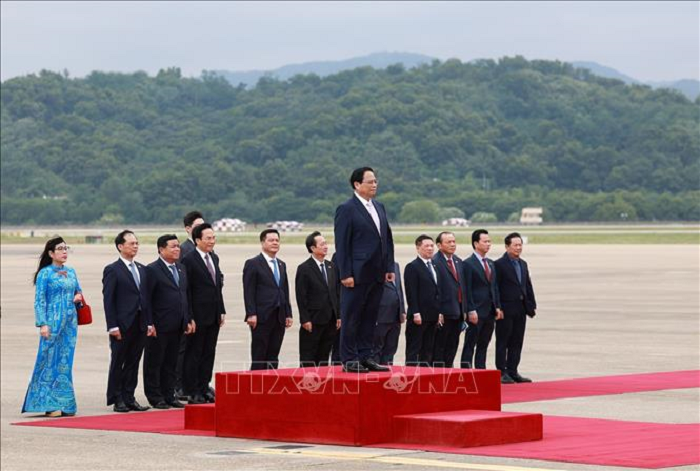 Thủ tướng Phạm Minh Chính nghe quân nhạc cử Quốc thiều. (Ảnh: Dương Giang/TTXVN)