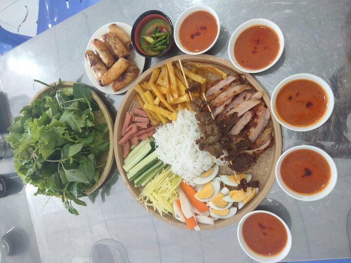 Thưởng thức chả cuốn cá trích cầu kỳ với rất nhiều rau sống, bún, nem chả ăn kèm. (Ảnh: K. Oanh)