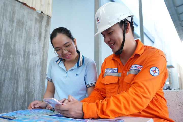 Nhân viên EVNSPC hướng dẫn khách hàng cài App CSKH, tham gia cuộc thi tiết kiệm điện.