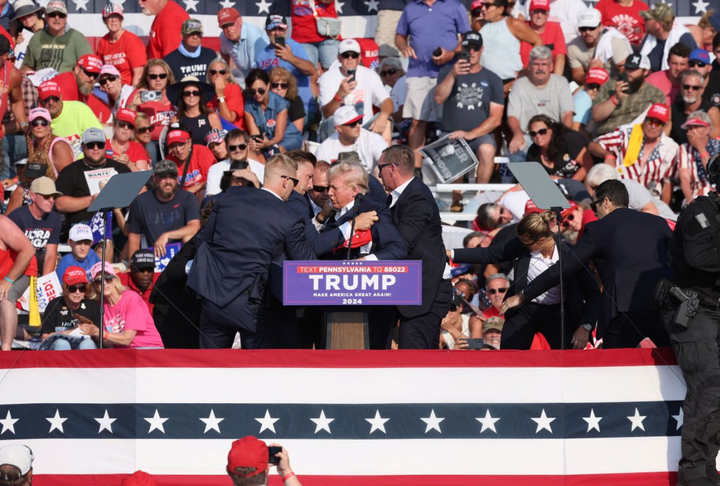 Cựu Tổng thống Trump được đưa khỏi hiện trường sau khi bị thương. (Ảnh: Reuters)