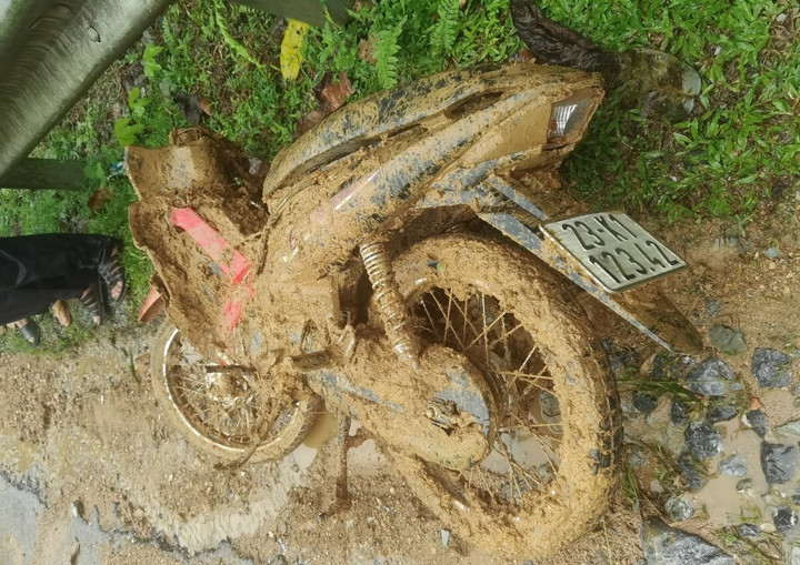 Trong lúc cứu người, xe máy của anh Tài bị đất đá vùi lấp, hư hỏng.