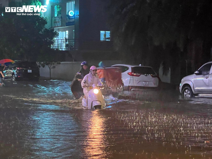 Người dân lội nước về nhà trong cơn mưa lớn.