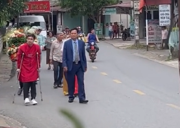 Chú rể tươi cười chống nạng đi hỏi vợ. (Ảnh cắt từ clip)