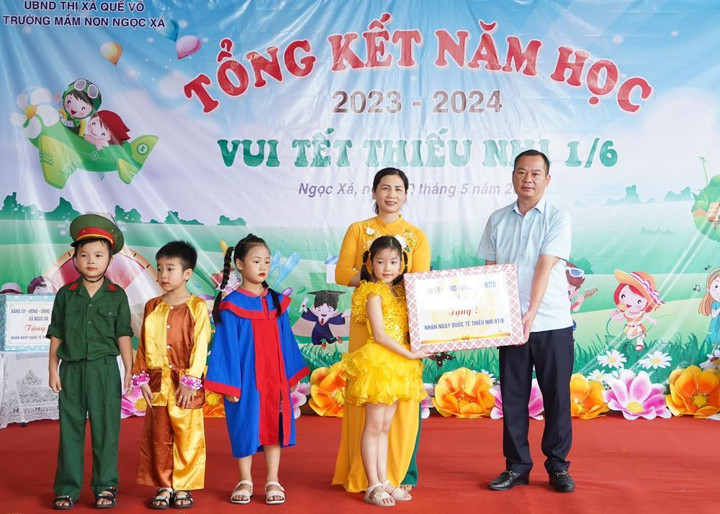 Ông Nguyễn Đức Lợi, Phó Bí thư Thường trực Thị ủy Quế Võ tặng quà cho cô, trò Trường mầm non Ngọc Xá.