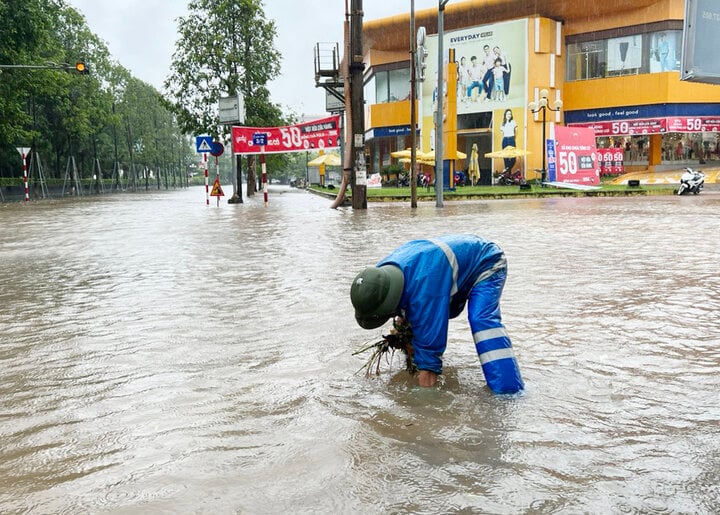 Công nhân Công ty cổ phần Quản lý công trình đô thị Bắc Giang kiểm tra hệ thống thoát nước toàn, vớt rác đọng ở các cửa hố ga, mở cửa thu nước ở những điểm ngập sâu. (Ảnh: BBG)