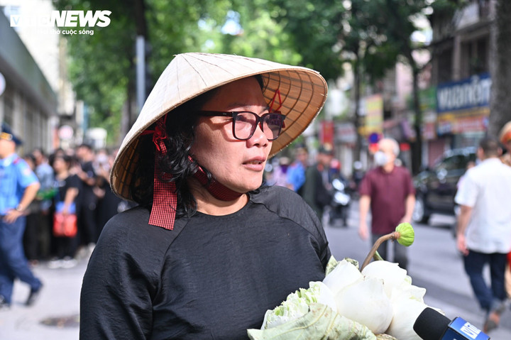 Người phụ nữ mang theo bó sen trắng vào viếng Tổng Bí thư Nguyễn Phú Trọng.