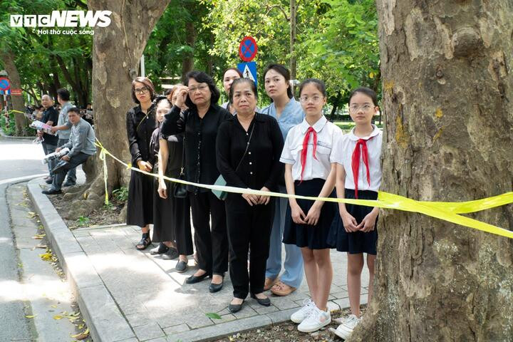 Các em học sinh cấp 2 có mặt trong dòng người chờ tiễn đưa Tổng Bí thư trên đường Điện Biên Phủ. (Ảnh: Thạch Anh)