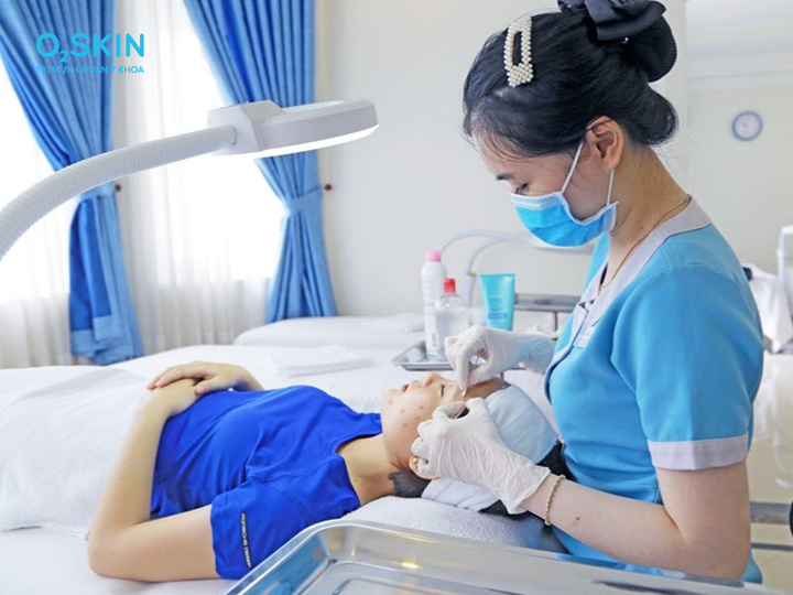 Điều dưỡng O2 SKIN đang thực hiện lấy nhân mụn chuẩn y khoa bằng tăm bông vô khuẩn cho khách hàng.