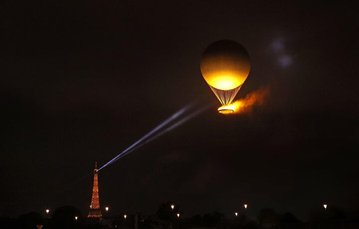 Ngọn lửa Olympic Paris 2024 được neo giữ trên một khinh khí cầu. Lễ khai mạc Thế vận hội năm nay kéo dài trong 4 giờ đồng hồ và đi vào lịch sử với kịch bản ấn tượng chưa từng có.