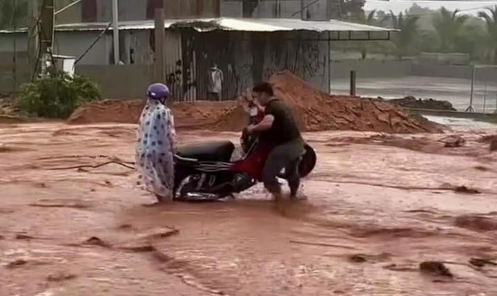 Xe máy bị lún bánh được người dân hỗ trợ (Ảnh: Thái An)