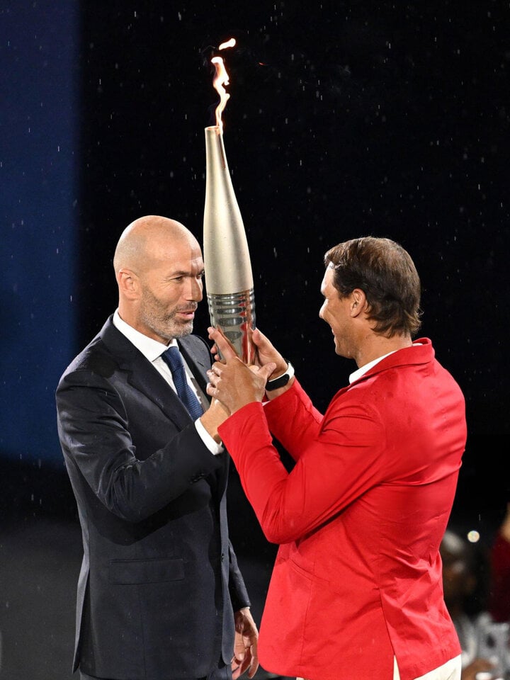 Huyền thoại bóng đá Pháp Zinedine Zidane trao ngọn lửa Olympic cho tay vợt người Tây Ban Nha Rafael Nadal. Trước đó là phần tuyên thệ của Florent Manaudou và Mélina Robert-Michon - 2 VĐV chủ nhà.