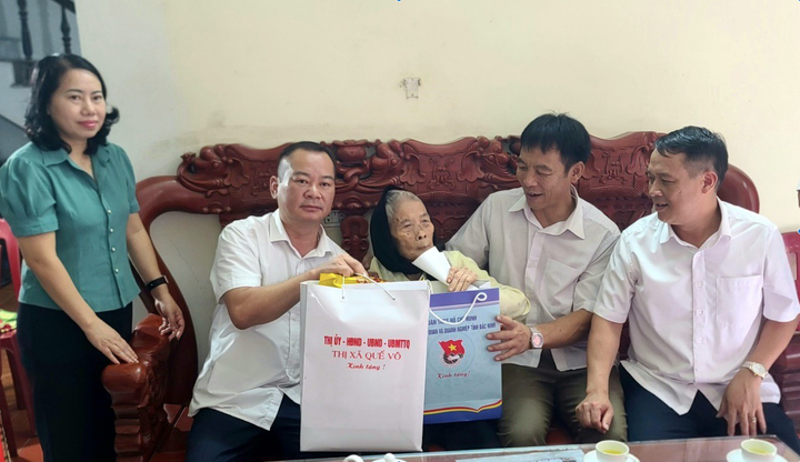 Ông Nguyễn Đức Lợi, Phó Bí thư Thường trực Thị Quế Võ ( thứ 2 từ trái sang), tặng quà Mẹ Việt Nam Anh hùng.