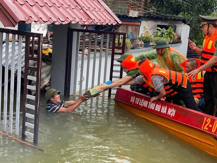 Lực lượng chức năng hỗ trợ người dân vùng mưa lũ.