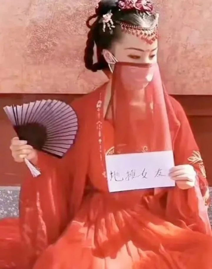 Cô gái mặc trang phục truyền thống và cầm bảng ghi tìm bạn đồng hành. (Ảnh: Baidu)