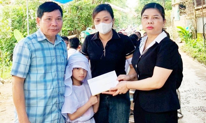 Đại diện lãnh đạo Phòng Lao động - Thương binh và Xã hội huyện Sơn Động cùng chính quyền địa phương trao tiền hỗ trợ gia đình chị Y.