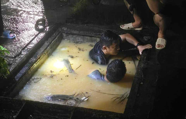 Lãnh đạo, cán bộ phường Hồng Hà và Ban Quản lý dự án, dịch vụ công ích TP Hạ Long mở nắp cống xử lý ngập úng ngay trong đêm. (Ảnh: Cổng thông tin điện tử tỉnh Quảng Ninh)