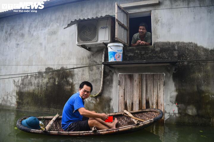 Anh Vũ Đình Nghì được hàng xóm hỗ trợ qua ô cửa sổ nhỏ. (Ảnh: Đức Anh)
