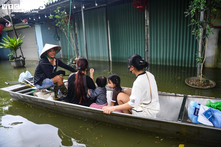 Anh Nguyễn Văn Tấn lái thuyền máy đưa khách ra ngoài vùng ngập mua sắm rồi lại đưa vào. (Ảnh: Đức Anh)