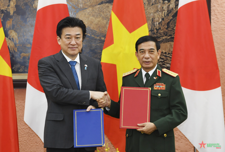 Đại tướng Phan Văn Giang và Bộ trưởng Kihara Minoru trao đổi Thư thỏa thuận và Biên bản thực hiện việc Nhật Bản chuyển giao 2 xe vận chuyển vật liệu đa năng phục vụ công tác cứu hộ-cứu nạn cho phía Việt Nam. (Ảnh: TUẤN HUY)