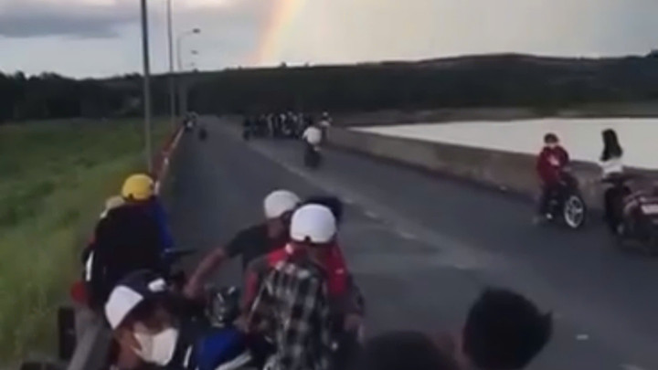 Nhóm thanh niên tụ tập 2 bên đường, nghi đua xe. (Ảnh cắt từ clip)