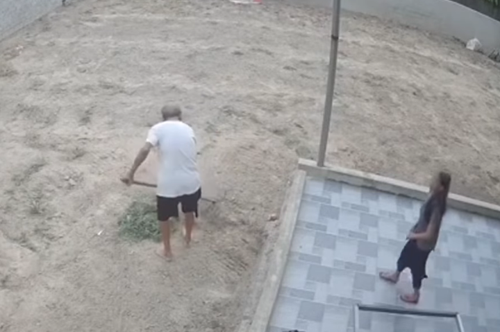 Cụ ông đang làm vườn thì cụ bà ra nhờ buộc tóc. (Ảnh cắt từ clip)