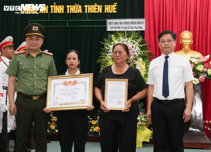 Ông Nguyễn Thanh Bình - Phó Chủ tịch thường trực UBND tỉnh và Đại tá Nguyễn Thanh Tuấn - Giám đốc Công an tỉnh Thừa Thiên - Huế trao bằng "Tổ quốc ghi công" cho thân nhân liệt sỹ Trần Duy Hùng. (Ảnh: CACC)