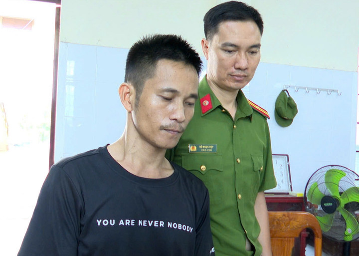 Cán bộ công an đang áp giải Trần Thanh Biền đi lấy lời khai. (Ảnh: Công an Quảng Trị)