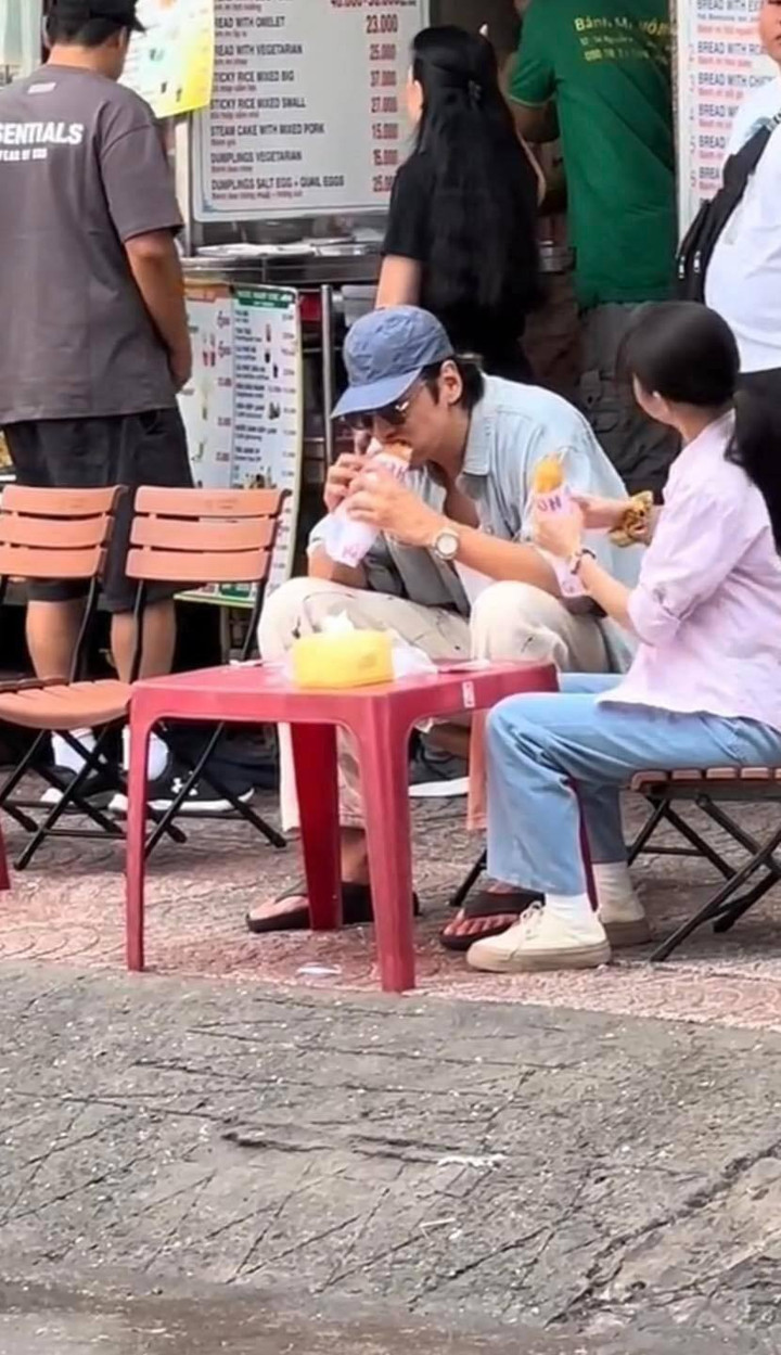 Nam diễn viên Lee Kwang Soo ngồi vỉa hè ăn bánh mì ở TP.HCM.